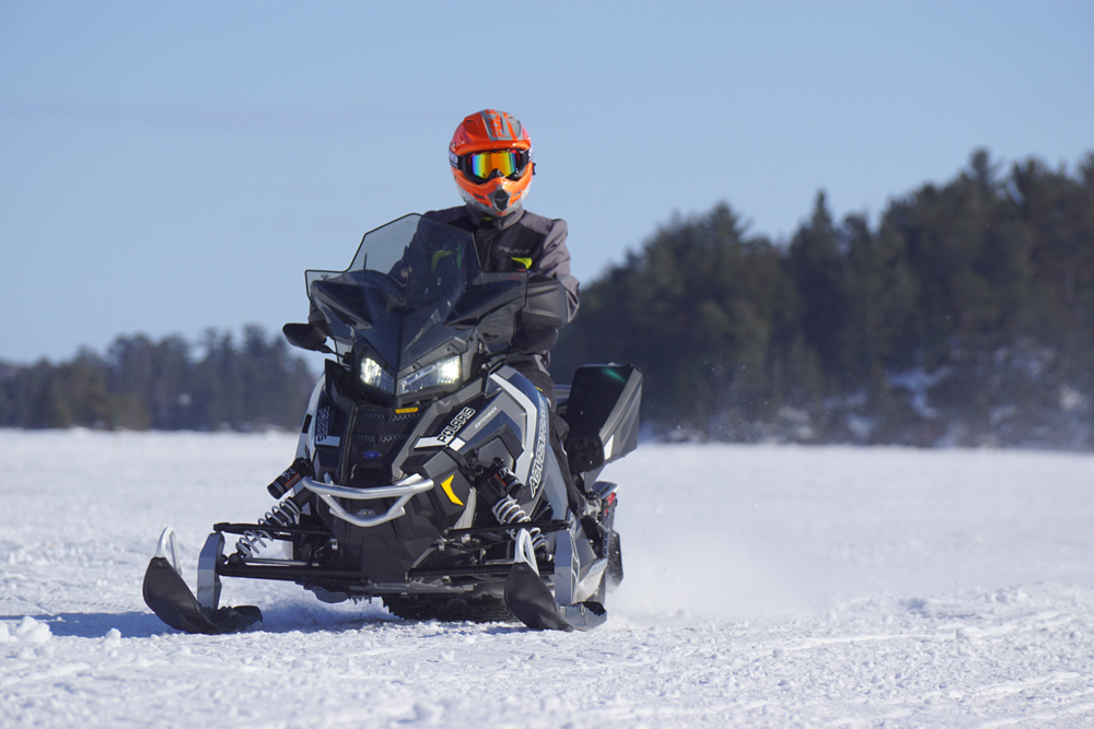 Man Riding Polaris Trail Snowmobile 