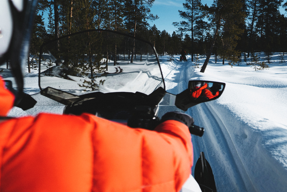 Rider on Snowmobile on trail in forest 
